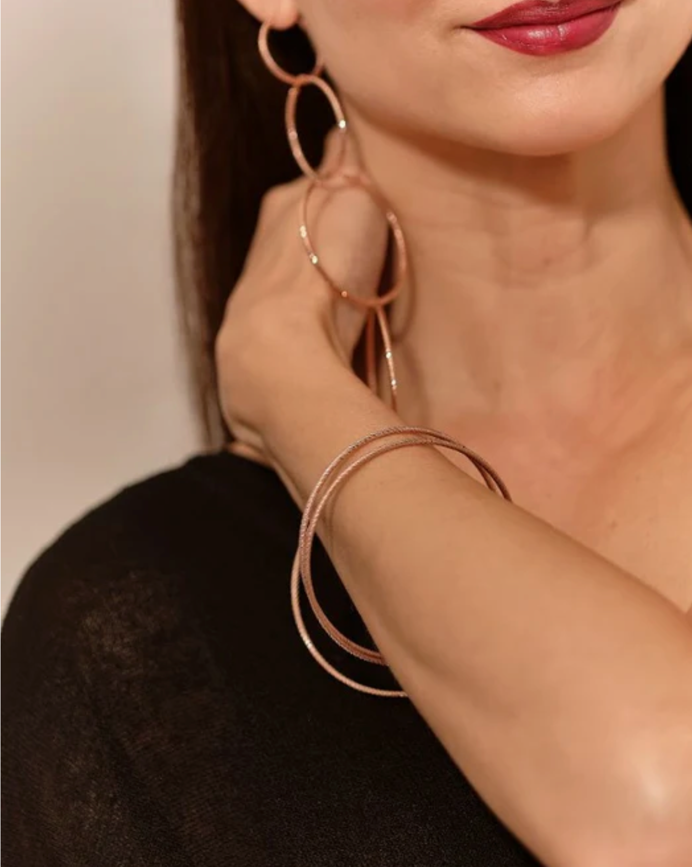 Close-up rose gold hoop earrings & matching bangle.