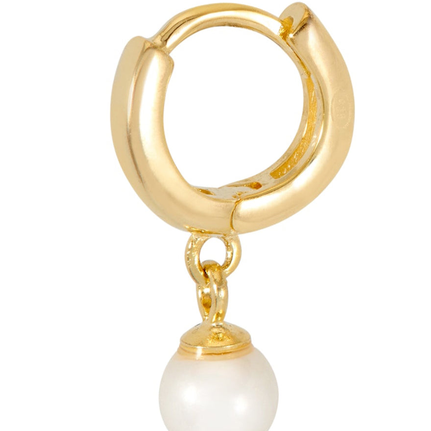 Gold hoop earring with a pearl charm on a white background
