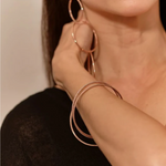 Close-up rose gold hoop earrings & matching bangle.