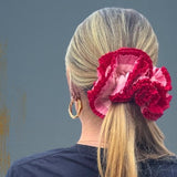 Person wearing a 'The Hoop Station' t-shirt in a modern room with a large window.